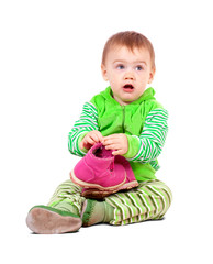 child holding shoes over white