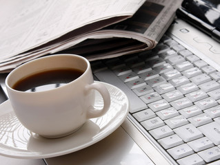 Cup of fragrant coffee on a morning paper