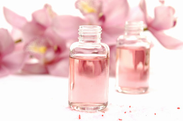 Obraz na płótnie Canvas bottle of massage oil with branch orchid - beauty treatment
