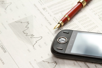 A mobile phone and a pen on papers