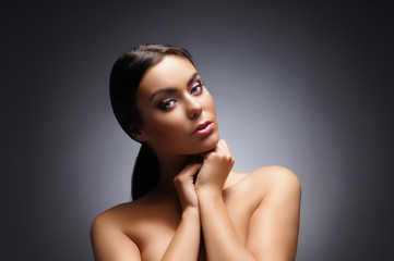 Fototapeta premium Portrait of a young and beautiful woman over grey