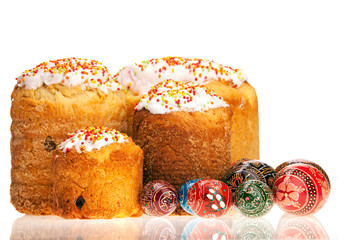 Easter cakes and painted eggs over white background