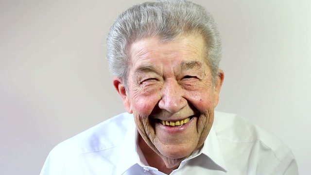 Senior lacht, redet und hebt den Daumen