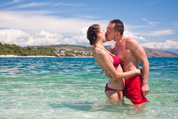Fototapeta na wymiar Handsome couple kissing in sea