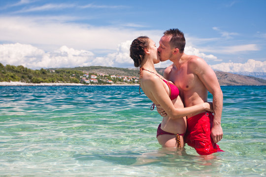 Handsome couple kissing in sea