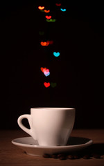 cup of coffee on wooden table on bright bokeh backdground