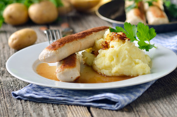 Deftige Wollwürste mit Kartoffelpüree und heller Soße