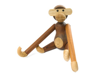 Toy wooden monkey sitting on a white background.