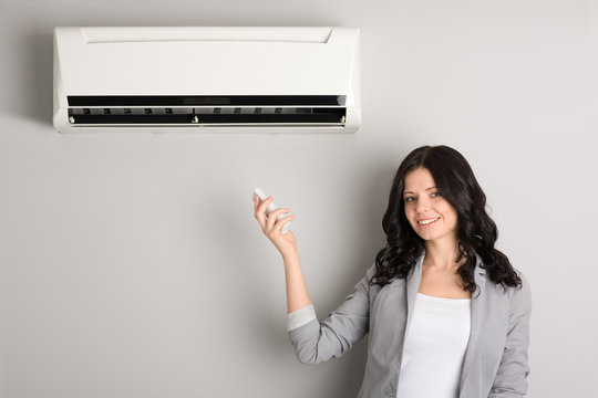 girl holding a remote control air conditioner