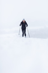 Fototapeta na wymiar Biegi narciarskie: młoda kobieta narciarstwo biegowe na śniegu