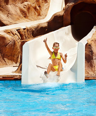 Child on water slide at aquapark.