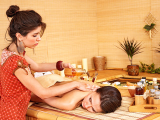Obraz na płótnie Canvas Woman getting massage in bamboo spa.