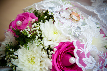 Wedding rings on a wedding bouquet.