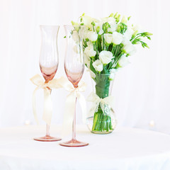 Vase of flowers and wedding glasses on the table