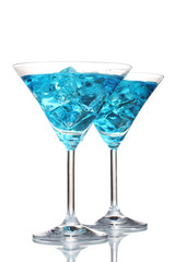 Blue cocktail in martini glasses with ice isolated on white