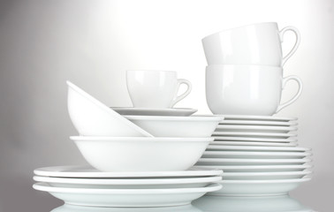 empty bowls, plates and cups on gray background