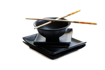 black asian bowl and plates with sticks