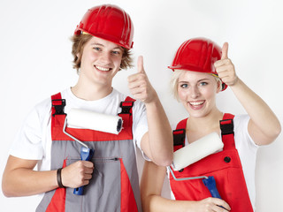 Two worker showing thumps up after painting a wall
