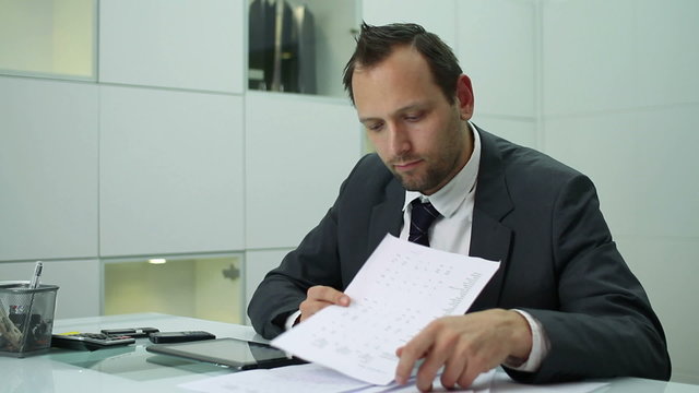 Worried businessman with tablet and paperwork