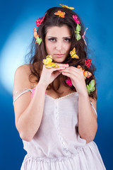 Beautiful girl with butterflies in hair isolated on blue