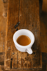 Obraz premium espresso coffee in thick white cup on old wooden bench