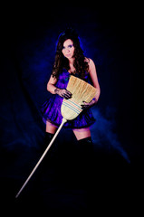Obraz na płótnie Canvas Sexy girl in witch costume holding her broom
