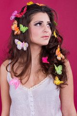 Beautiful girl with butterflies in hair isolated on red