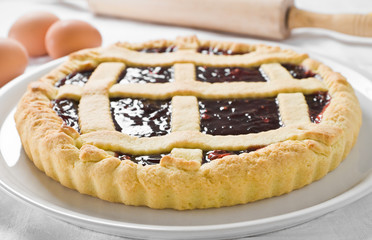 Breakfast with jam tart in white dish.