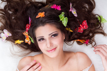 Beautiful girl with butterflies in hair isolated on white