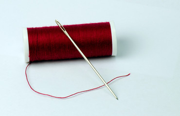 Nähnadel und roter Garn