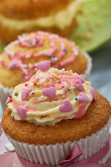Mit Herzen und Zuckerstreusel verzierter Cupcake