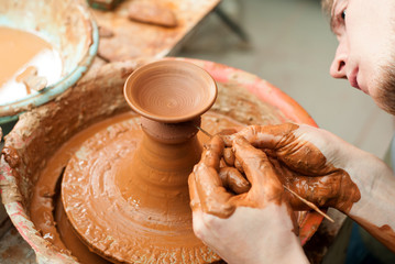 hands of a potter, creating an earthen jar on the circle