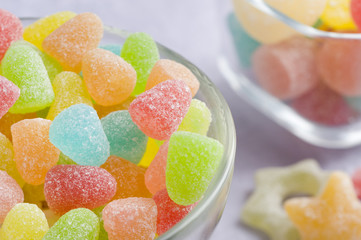 Multicolor gummy candy, glass bowl, blue background, star shaped
