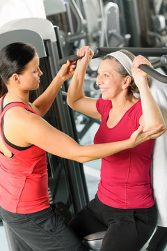 Personal Trainer Assist Senior Woman At Gym