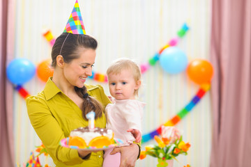 Fototapeta na wymiar Mother showing baby birthday cake