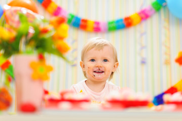 Portrait of eat smeared baby celebrating first birthday