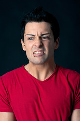 Obraz premium Man portrait with angry expression on dark background.