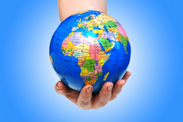 Hand holding globe against gradient