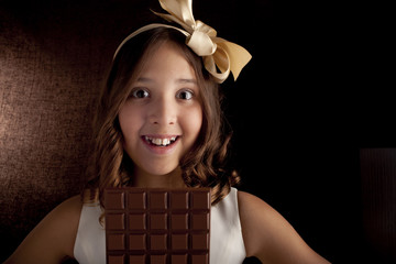 girl with big chocolate, bow on a head looking at camera