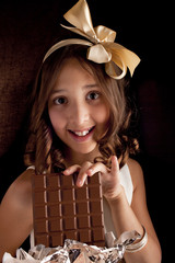 girl with big chocolate ,bow on a head looking at camera