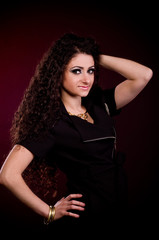 Naklejka premium Beautiful young woman in dress on dark background.