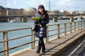 Obraz premium Happy beautiful girl with tulips enjoying spring day in Paris