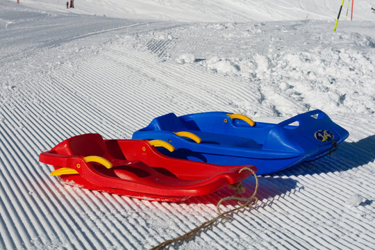 luges rouge et bleu sur la neige