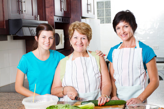 Happy Grandmother Cooking With Her Daughter And Granddaughter