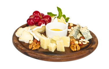 Various types of cheese with honey, nuts and grapes on plate, is
