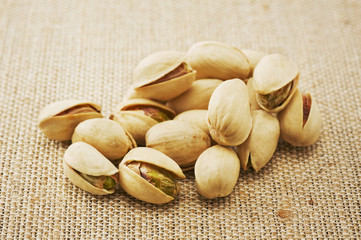 麻布の背景に複数のピスタチオ