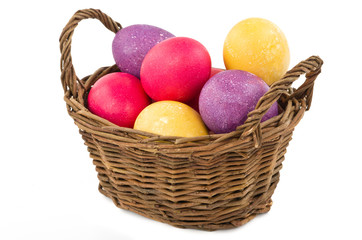 Full basket of colored easter eggs over white