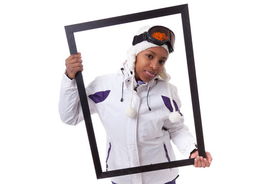 Young black woman in ski clothes holding a picture frame