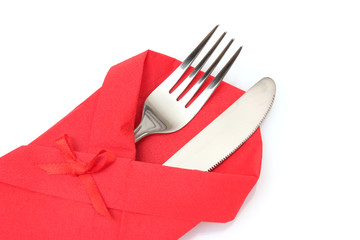 Fork and knife in a red cloth with a bow isolated on white