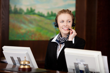 freundliche empfangsdame telefoniert mit headset